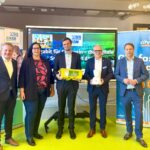 Fünf Personen stehen nebeneinander, eine davon hält ein LEGO Education SPIKE Set in den Händen.