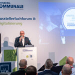 Fabian Mehring spricht auf einem Podium der Kommunale.