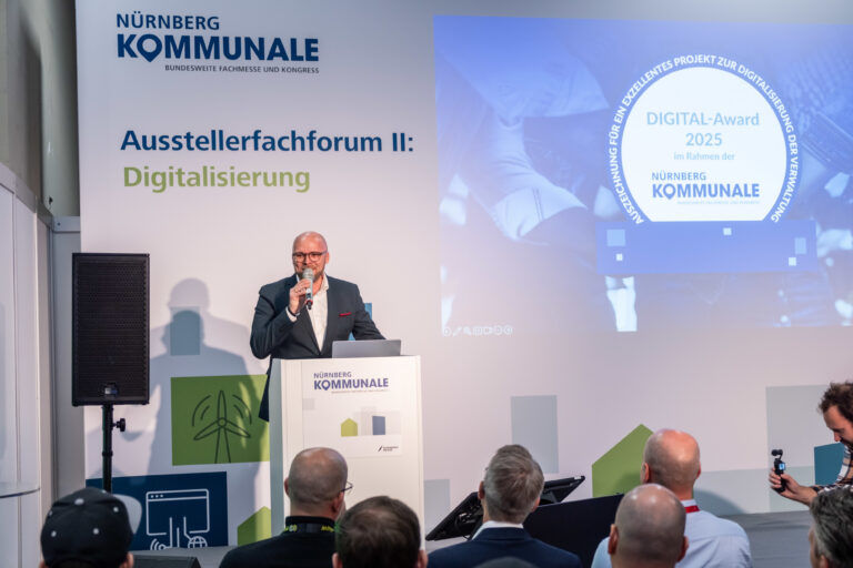 Fabian Mehring spricht auf einem Podium der Kommunale.