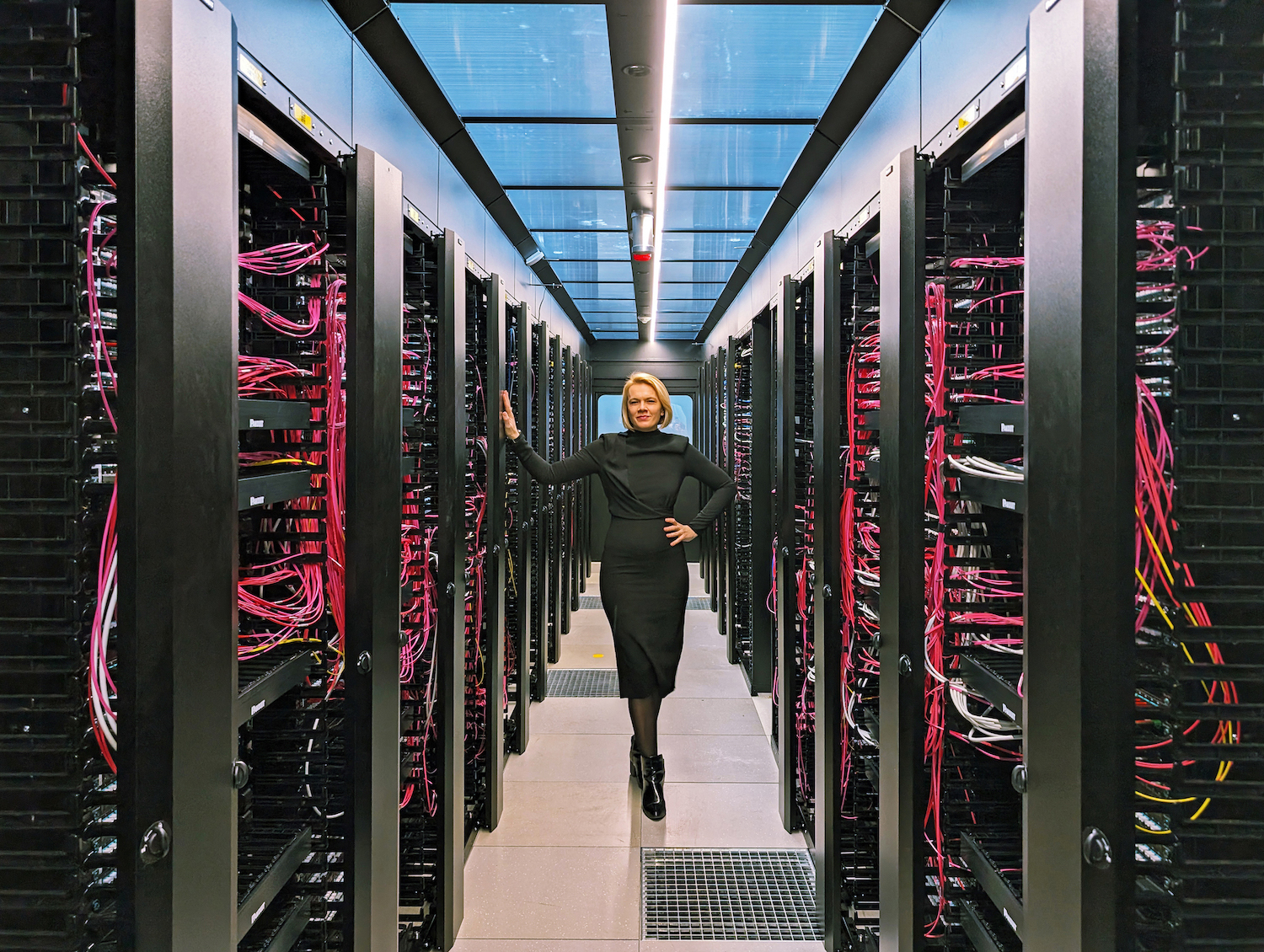 Eine Frau steht inmitten eines Rechenzentrums.