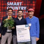 GovIntel gewinnt Startup Award. Drei Männer mit Blumenstrauß und Urkunde.