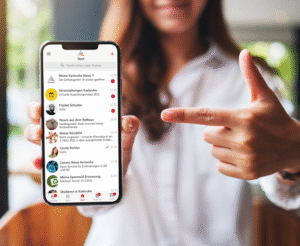 Eine Frau präsentiert ein Smartphone, auf dem die Karlsruhe.App genutzt wird.
