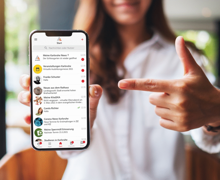 Eine Frau präsentiert ein Smartphone, auf dem die Karlsruhe.App genutzt wird.