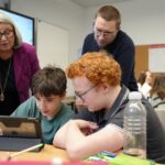 4 Personen stehen um Laptop - Einführung telli in SH