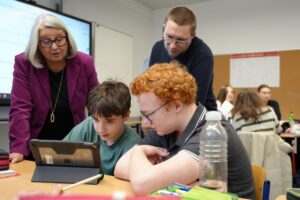 4 Personen stehen um Laptop - Einführung telli in SH