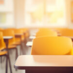 Leerer Klassenraum, freundliche Atmosphäre, Blick über Stuhlreihen und Tische.