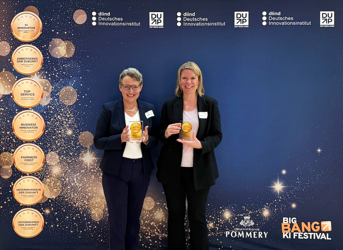 Zwei Personen nehmen für URBAN.KI den Business Innovator Award entgegen