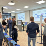 Workshopsituation während des FORUM : In einem Konferenzraum stehende und diskutierende Gruppe von Männern..