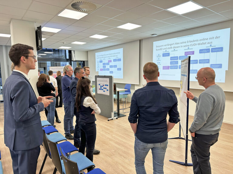 Workshopsituation während des FORUM : In einem Konferenzraum stehende und diskutierende Gruppe von Männern..