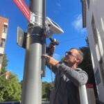 Ein Mann installiert einen Smart-City-Sensor an einer Straßenlaterne in Grevenbroich.