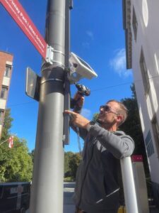 Ein Mann installiert einen Smart-City-Sensor an einer Straßenlaterne in Grevenbroich.