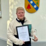 Mann mit Urkunde und Preis alpenrod-App geehrt