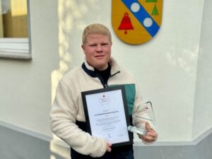 Mann mit Urkunde und Preis alpenrod-App geehrt