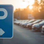 Ein Parkplatzschild steht am Eingang eines Freiluftparkplatzes.