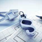 Ein Schlüsselbund mit einem Anhänger in Paragrafenform liegt auf dem Grundriss eines Gebäudes.