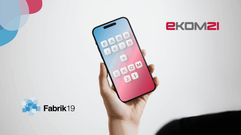 Eine Person hält ein Smartphone in der Hand auf dessen Bildschirm die Namen Fabrik19 und ekom21 zu sehen sind.