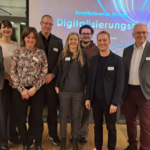 Mehrere Personen stehen nebeneinander in einem Raum.