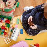 Kleinkinder spielen mit Bauklötzen.