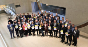 Eine größere Personengruppe steht in einem Raum für ein Foto versammelt und halten in den Händen Förderurkunden für den Breitbandausbau in Baden-Württemberg.