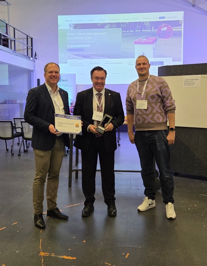 Drei Personen stehen nebeneinander in einem Raum und halten eine Urkunde und den Milesight Impact Award 2025 in den Händen.