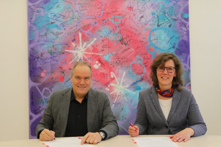 Zwei Personen unterzeichnen eine Absichtserklärung