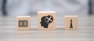 Holzklötze mit Icons: Buch, Hirn, Schachfigur