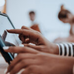 Eine Person bedient den Touchscreen eines Tablets.