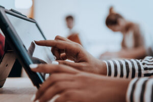 Eine Person bedient den Touchscreen eines Tablets.