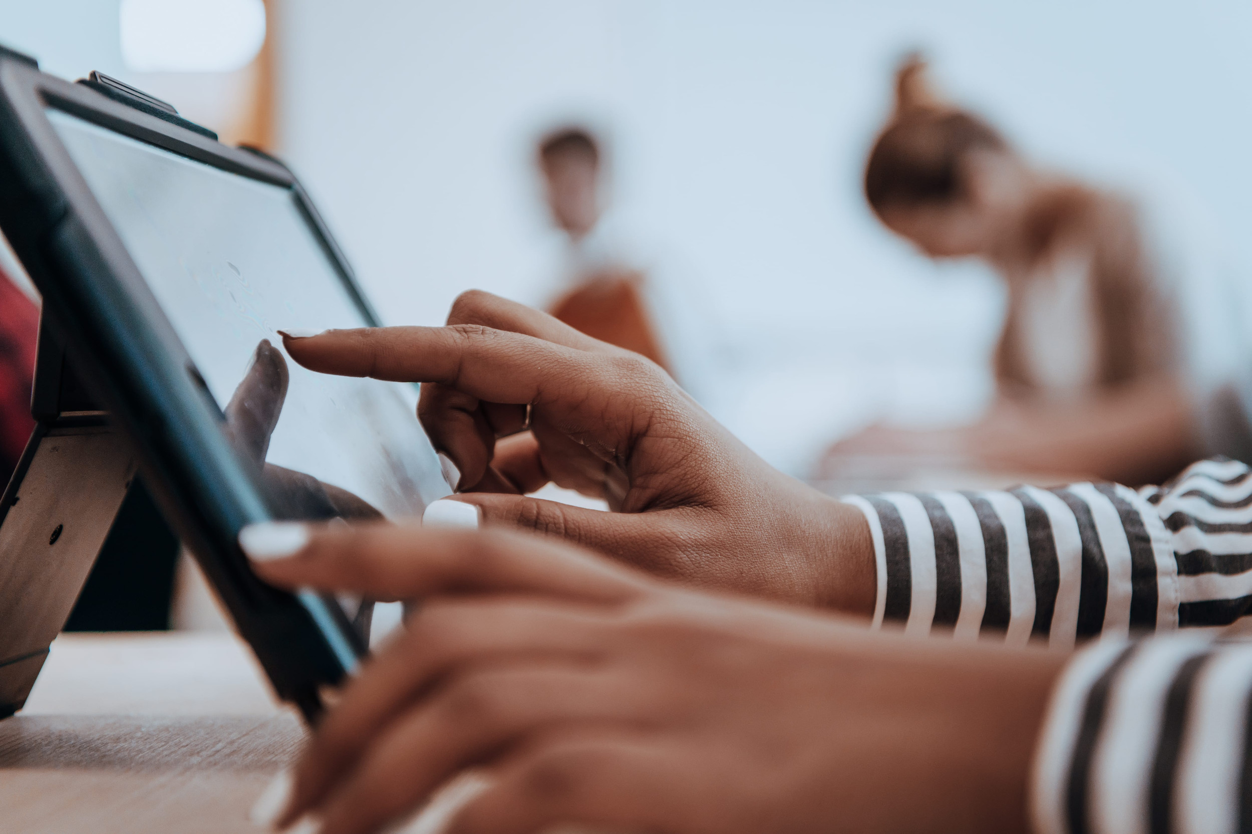 Eine Person bedient den Touchscreen eines Tablets.