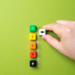 Eine Person markiert einen Score, bestehend aus verschiedenfarbigen Würfeln.