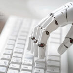 Roboterhand tippt auf einem Computerkeyboard