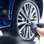 In einer Werkstatt wird die Felge an einem Autoreifen befestigt.