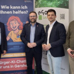 Mehrere Personen stehen nebeneinander, im Hintergrund sind Aussteller des eGo-Saar und von Gerda BürKI zu sehen.