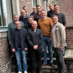 Mehrere Personen stehen zum Gruppenfoto versammelt auf einer Außentreppe.