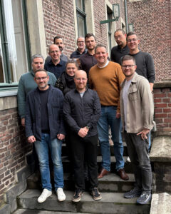 Mehrere Personen stehen zum Gruppenfoto versammelt auf einer Außentreppe.