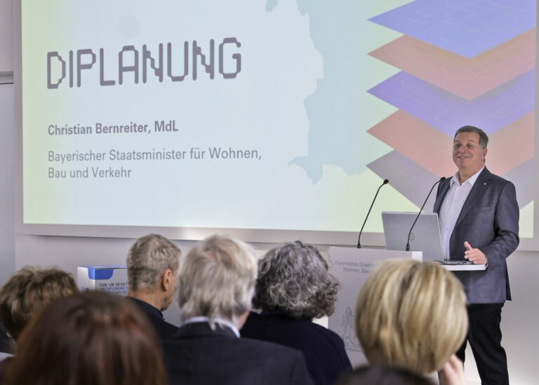 Bayerns Bauminister Christian Bernreiter am Rednerpult, im Vordergrund Publikum.
