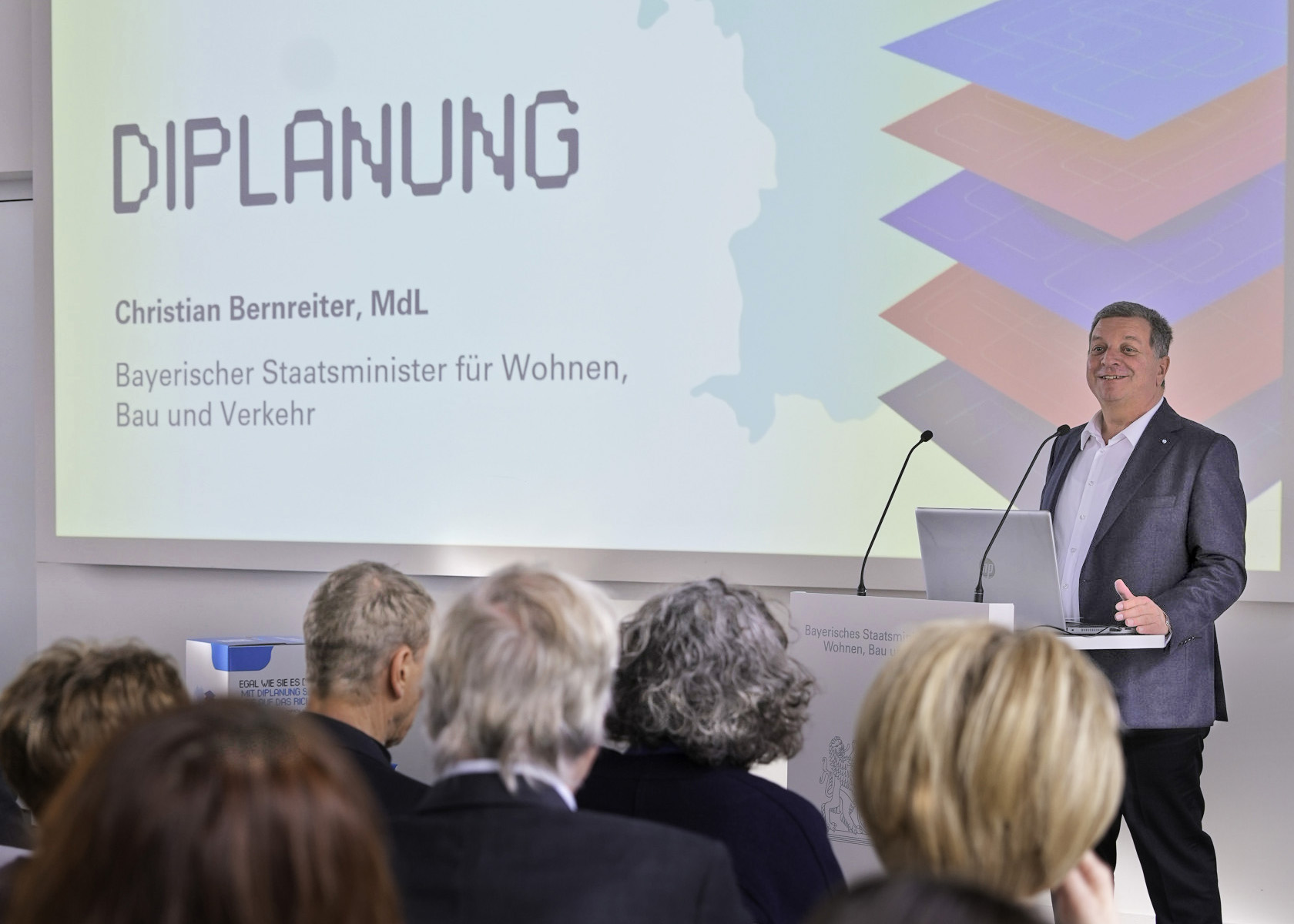 Bayerns Bauminister Christian Bernreiter am Rednerpult, im Vordergrund Publikum.