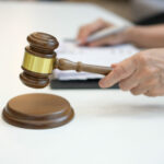 Richter hält Hammer in der Hand im Gerichtssaal