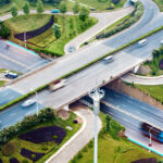 Luftaufnahme: Autobahnabschnitt mit Abfahrten und mehrspurigen Brücken