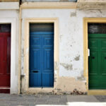 Altstadtgasse mit nebeneinander liegenden Holztüren in verschiedenen Farben