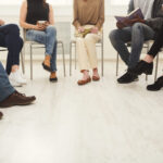 Eine Gruppe von Personen sitzt wartend auf Stühlen