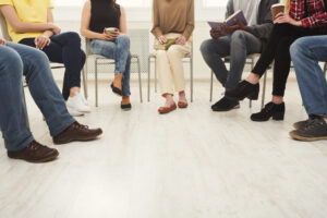 Eine Gruppe von Personen sitzt wartend auf Stühlen