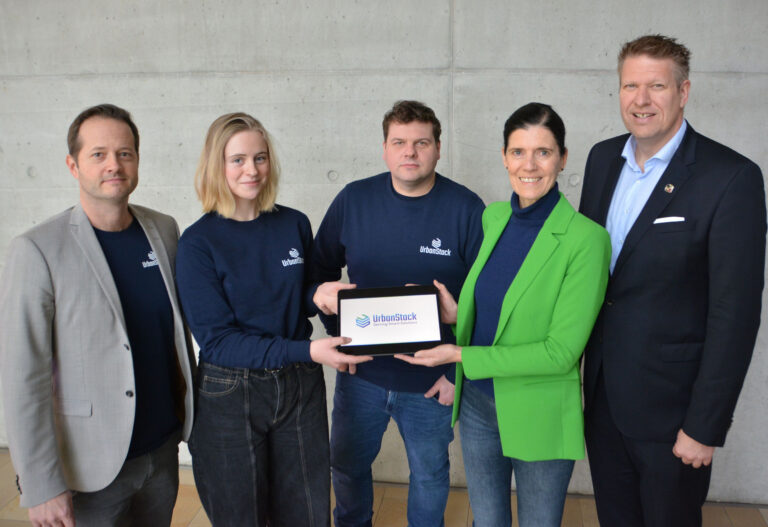 Fünf Personen, der in der Mitte hält ein Tablet_Gütersloh stellt Urban Stack vor