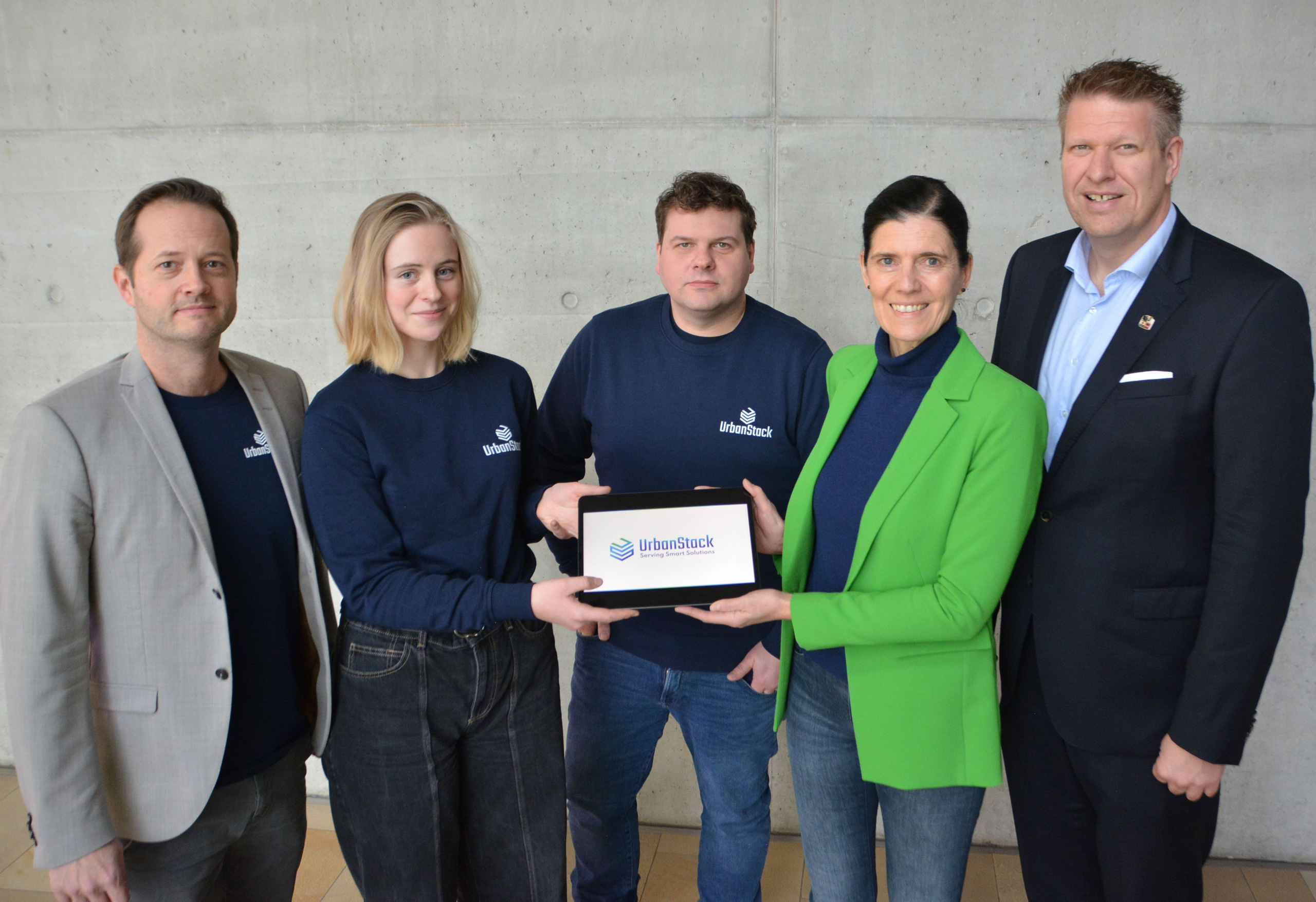 Fünf Personen, der in der Mitte hält ein Tablet_Gütersloh stellt Urban Stack vor