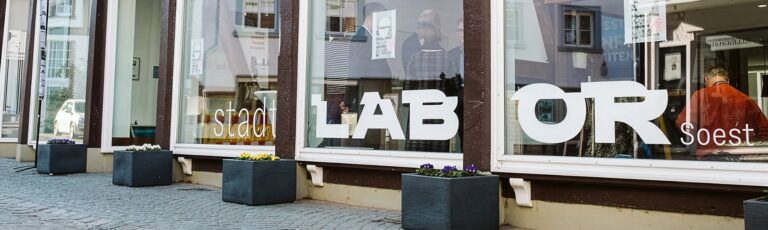 Blick von Außen durch die Glasfront eines Ladengeschäfts ins Stadtlabor Soest
