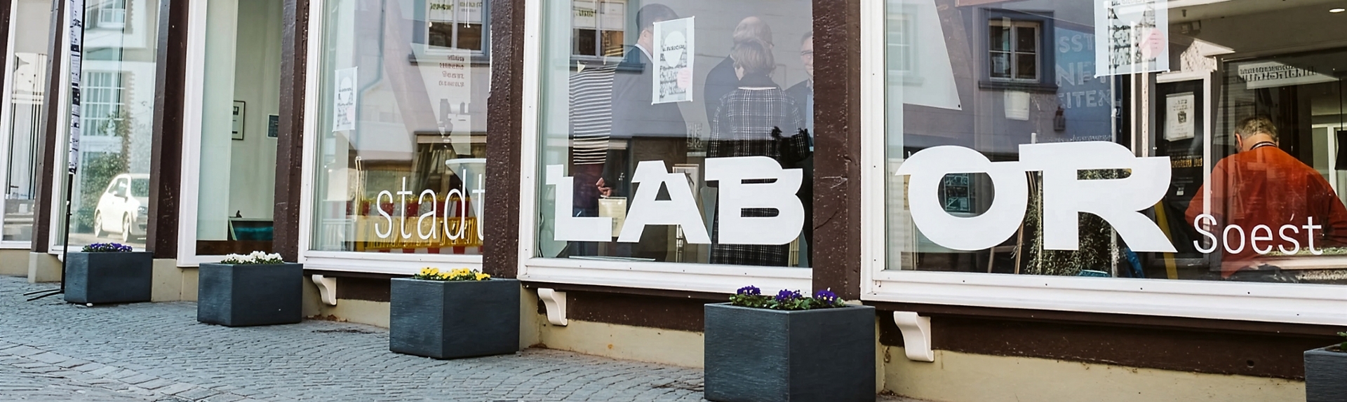 Blick von Außen durch die Glasfront eines Ladengeschäfts ins Stadtlabor Soest