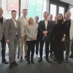 eine Reihe von Personen steht vor einer Wand