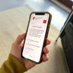 Hand hält Handy mit Website der Stadt Mainz, Relaunch