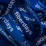 Haufen von blauen Werbe-Lanyards, die mit dem Schriftzug "fiberdays" bedruckt sind.