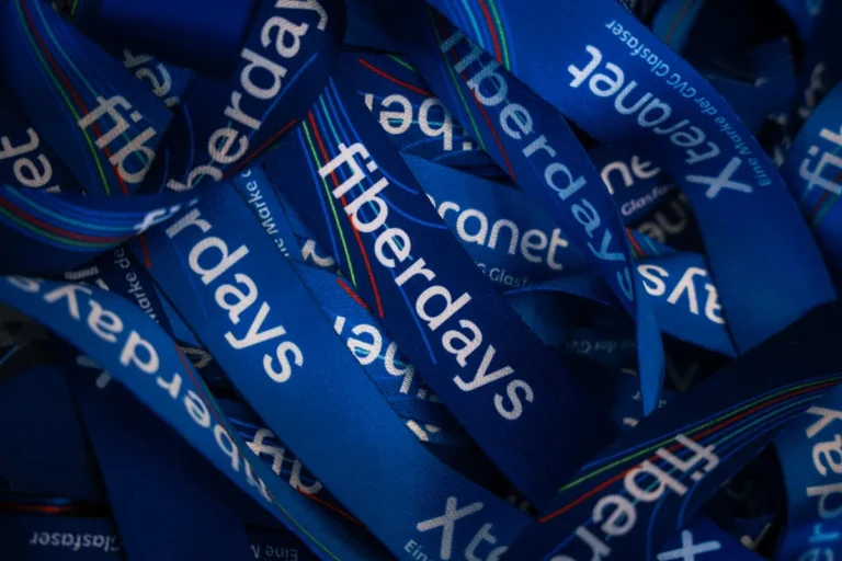 Haufen von blauen Werbe-Lanyards, die mit dem Schriftzug "fiberdays" bedruckt sind.